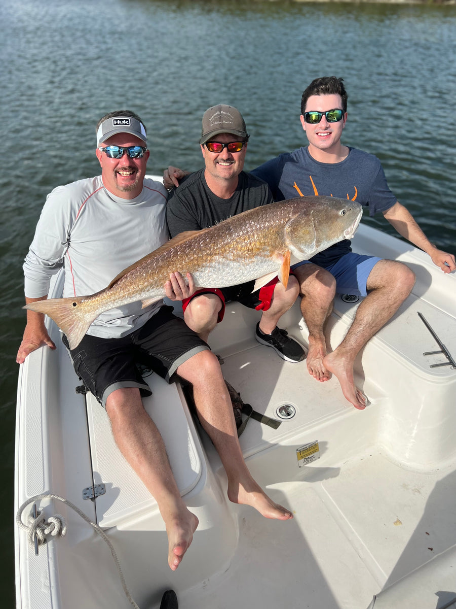 Three anglers with a matching pair of redfish