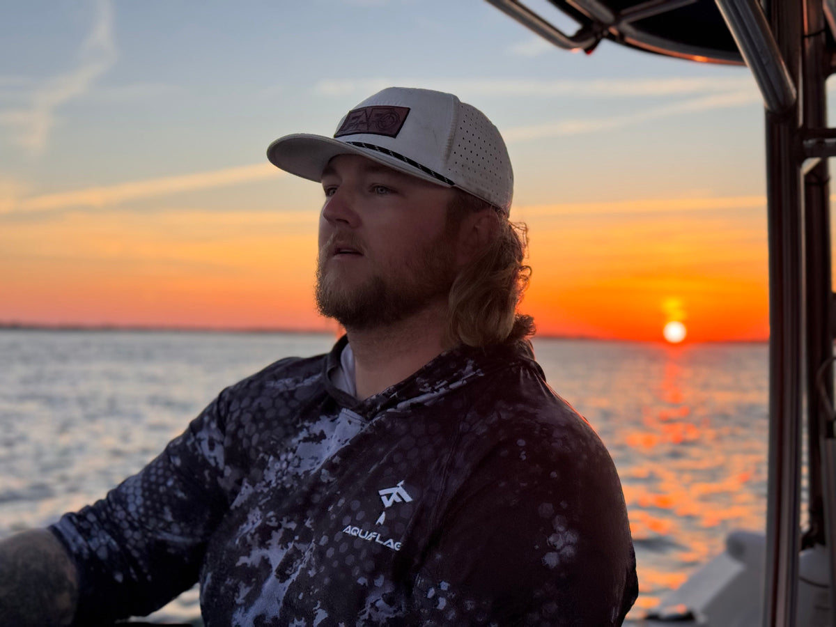 Captain at the helm as the sun comes up over the water