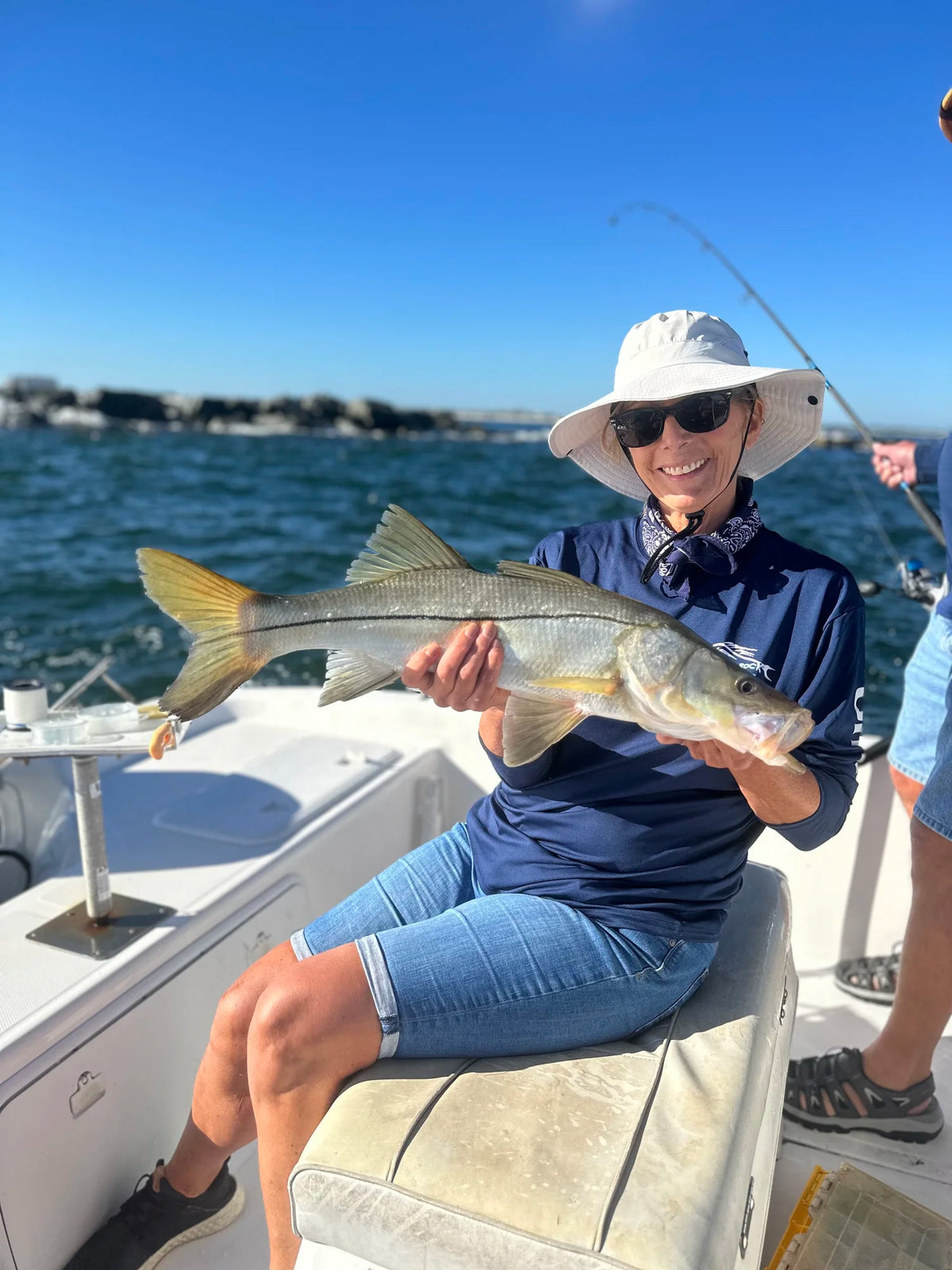 Smiling angler holding a big snook on a New Smyrna Beach fishing charter